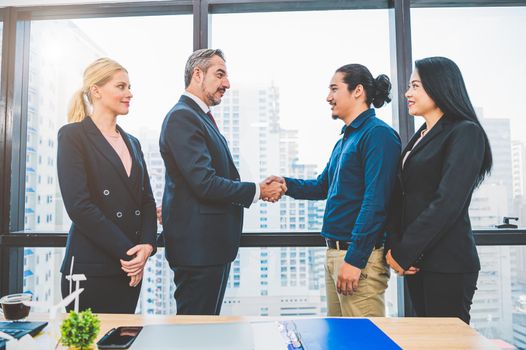 Business partnership meeting handshaking concept. Businessmen doing handshake. Successful business people contract handshaking after finished good dealing with skyscraper window building background.