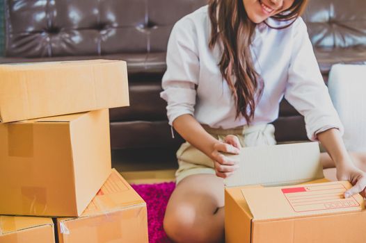 Asian business woman startup small business entrepreneur SME distribution warehouse with parcel mail box. small owner home office. Online marketing and product packaging and delivery service concept