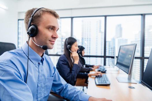 Group of young profession call center operator agent with headsets working in office. Business telemarketing service people concentrating on having conversation work and talking to customer friendly