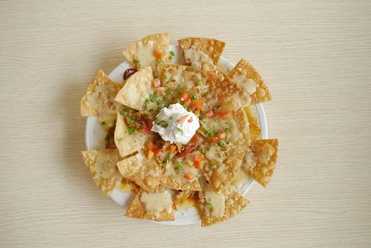 Corn chips nachos with fried meat on table