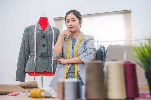 Fashion designer stylist in business owner workshop. Tailor and sewing concept. Portrait of happy casual trendy fashion designer businesswoman in studio looking camera. Business job and occupation