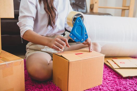 Closeup of Asian business woman hand startup small business entrepreneur SME distribution warehouse with parcel mail box. small owner home office. Online marketing and product packaging and delivery