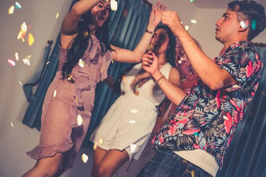 Happy friends dancing and having fun in New year party at night club. Event celebration and anniversary concept. People lifestyles and friendship.