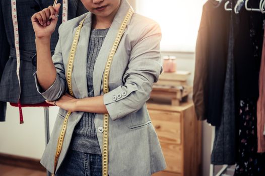 Closeup of lower body of fashion stylist designer in business owner workshop. Tailor and sewing concept. Portrait of happy casual trendy fashion designer businesswoman in studio. Job and occupation