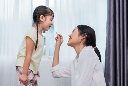 Young mother relaxing together with her little child. Adorable toddler girl in house  eating potato chip with mom together. Kids and beautiful woman. Family in love and Home sweet home concept.