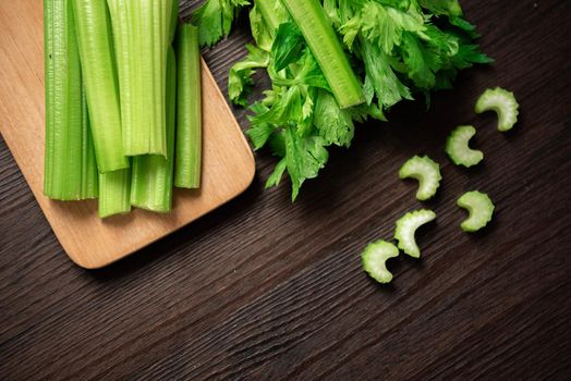 Top view of bunch of fresh sliced celery stalk on wooden table with leaves. Food and ingredients  of healthy vegetable. Freshness herbal and low calories for dieting with plenty of vitamin