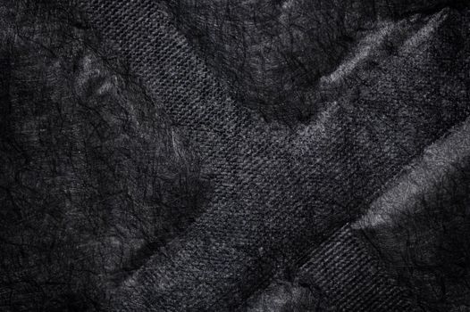 Black fabric canvas silk texture background. Abstract closeup detail of textile material wallpaper. X cross shape emboss