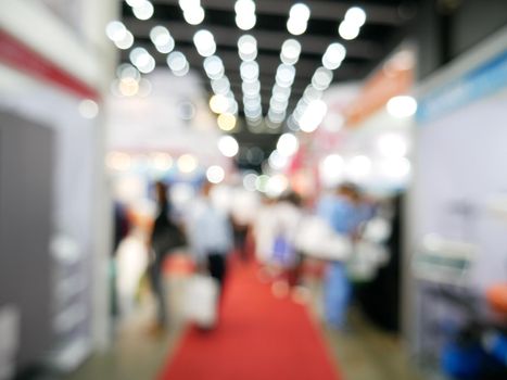 Blurry background of exhibition expo with crowd people in convention hall. Abstract concept. Business marketing and event theme.