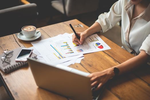 Close up of business woman working with documents and laptop in office. Business and Lifestyles concept. Entrepreneur and Freelance theme.