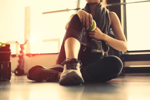 Sport woman exercise workout in fitness sport gym holding green apple. Girl relax after braking in club with protein shake bottle. Healthy athletic people muscle bodybuilder training lifestyle concept