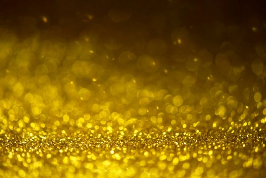 Gold glitter sparkle lights background. Defocused glitter abstract twinkly light and shiny stars. Christmas and New year party concept background. Closeup stardust. 