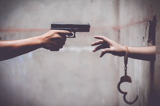 Escaped prisoner with a police gun. Breakaway prisoner and Police concept, Prohibited Law and Rule concept. Cross processing and split tone pinterest and instragram like process.