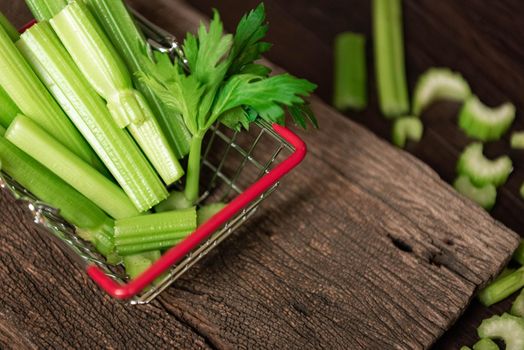 Bunch of fresh celery stalk in shopping basket with leaves. Food and ingredients  of healthy vegetable. Freshness herbal and low calories for dieting with plenty of vitamin