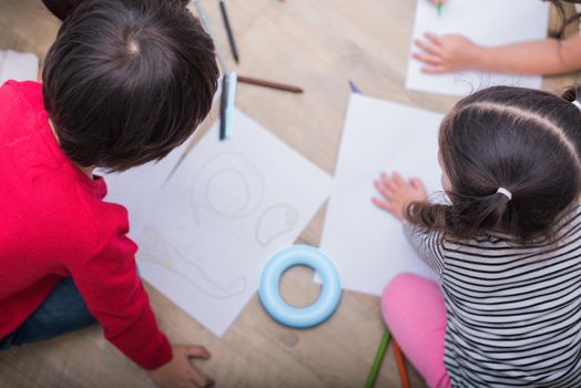 Group of preschool student and teacher drawing on paper in art class. Back to school and Education concept. People and lifestyles theme.  Room in nursery