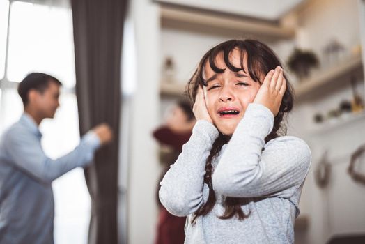 Little girl crying because of her parents quarreling. Girl abused with mother and father shouting and conflict angry background in home. Family dramatic scene, Family social issues problem concept.