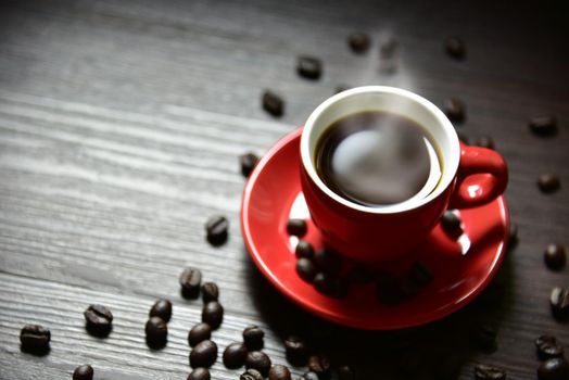Red cup coffee with smoke and coffee bean on wood table texture, selective focus on edge of cup, Drinking concept, Relax concept