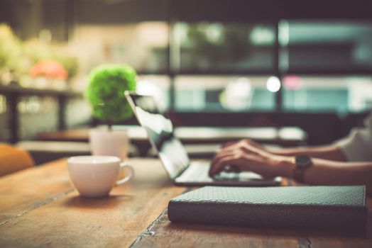 Close up of businesswoman working at office with laptop. Mobile phone and Marketing summary report graph data documents on desk. People and Lifestyles concept. Business and Financial theme.