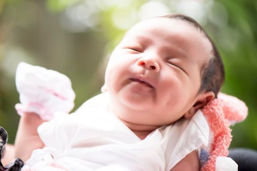 Newborn baby smiling in mother's hands, selective focus in her eyes, Family concept