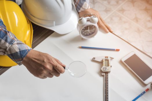 Engineer with magnify glass for looking blank paper for new project. Engineer and Architector concept, Business theme