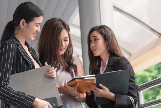Businesswomen discussing monthly report meeting conference. Group of business people sharing planning working experience at outside office. Secretary having conversation gossip about boss or coworkers