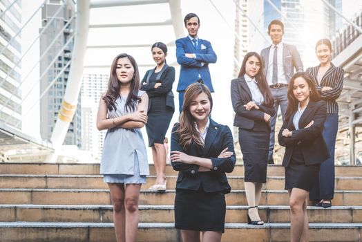 Portrait of successful group of business people at outdoor urban. Happy businessmen and businesswomen standing as team in satisfaction gesture. Successful group of people smiling and looking at camera