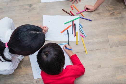 Group of preschool student and teacher drawing on paper in art class. Back to school and Education concept. People and lifestyles theme.  Room in nursery