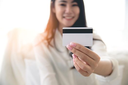 Close up of credit card holding by beauty Asian woman. Online shopping and easy payment concept.