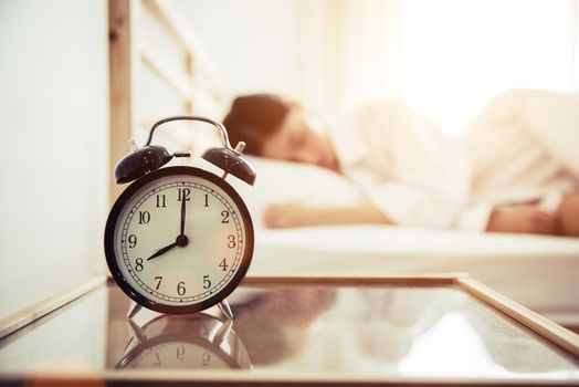 Alarm clock with beauty woman in background. Morning and Lazy time concept. Bedroom theme.