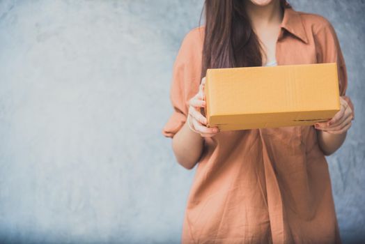 Woman holding parcel box for delivery to customer by logistic service. small business entrepreneur SME distribution warehouse concept. small  owner home office and Online marketing product theme