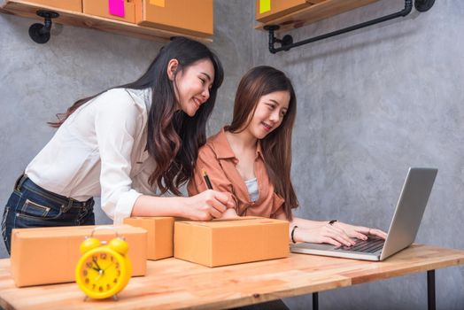 Two young Asian people startup small business entrepreneur SME distribution warehouse with parcel mail box. small  owner home office. Online marketing and product packaging and delivery service