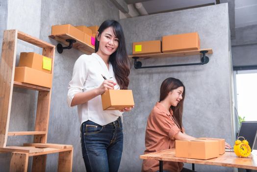 Two young Asian people startup small business entrepreneur SME distribution warehouse with parcel mail box. small  owner home office. Online marketing and product packaging and delivery service