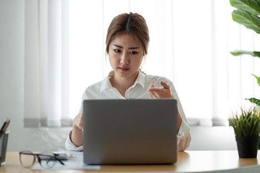 Asian woman watching educational webinar on laptop. Smiling young businessman holding video call with clients partners.