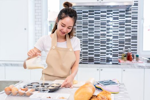 Asian beauty woman cooking and baking cookies in kitchen room on table. Holiday and Happiness concept. People and lifestyles concept. Family and dinner party theme. Girl enjoy making cake with apron