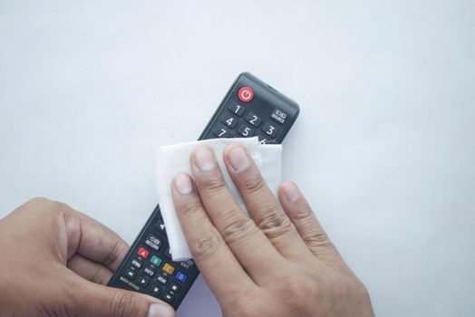 Cleaning Tv remote control with an antibacterial fabric tissue.