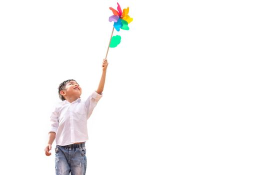 Boy holding colorful pinwheel in windy at outdoors. Children portrait and kids playing theme. Isolated on white background