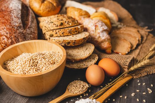 Different kinds of bread with nutrition whole grains on wooden background. Food and bakery in kitchen concept. Delicious breakfast gouemet and meal.