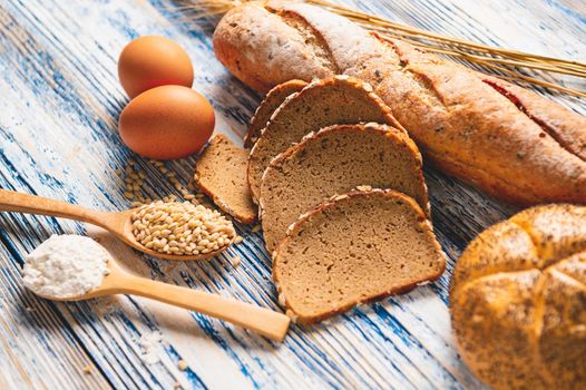 Different kinds of bread with nutrition whole grains on wooden background. Food and bakery in kitchen concept. Delicious breakfast gouemet and meal. Carbohydrate organic food cuisine homemade