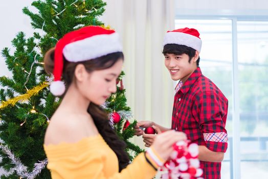 First impression of man to woman who prepare to decorating Christmas tree in New year festival. Xmas and Event concept. Love of Lovers and couples concept. Bed room and living room theme. Fall in love
