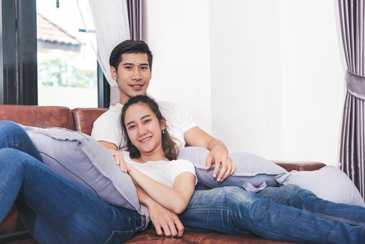 Sweet free time together. Happy beautiful lovers spending weekend together on couch or sofa indoors at home, Relaxing and Enjoying on couple concept in holidays