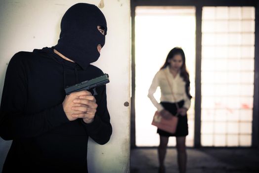 Robber holding up and waiting woman to steal her wallet or hand bag by hand gun in corner of building. Criminal sexual and Dangerous illegal violence crisis concept