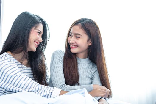 Two Asian Lesbian women in bedroom. Couple people and Beauty concept. Happy lifestyles and home sweet home theme. Cushion pillow element and window background.