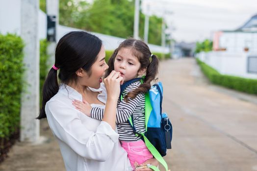 Mom feeding her daughter with snack before going to school. Back to school and Education concept. Home sweet home and happy family theme.