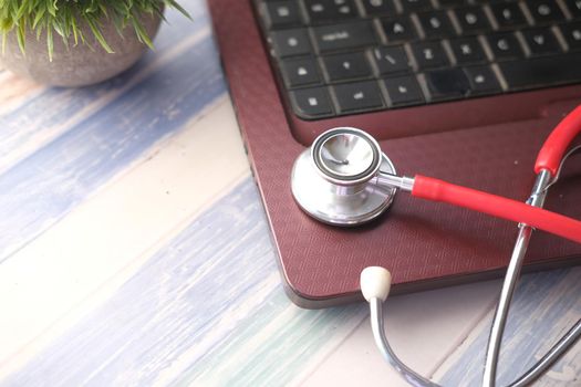 Medical Stethoscope on laptop on wooden table ,