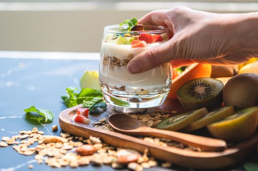 Closeup nutrition yogurt with many fruits on table and chef hand. Food cuisine and drinks concept. Organic dessert theme.