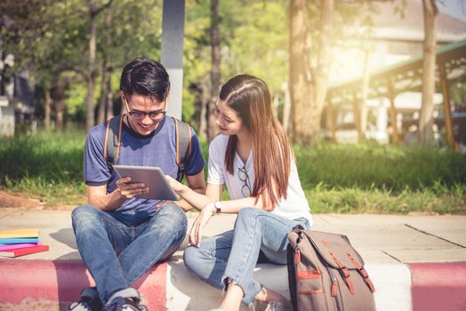 Two Asian young college people discussing about homework and final examination for testing. Education and Friendship concept. Happiness and Learning concept. Lovers and Friend theme.