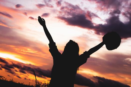 Silhouette of happy woman open arms under sunrise at seaside with sunset  background during travel in holiday. Strong confidence cheerful girl with dawn sky. Sun and nature. Weekend vacation concept