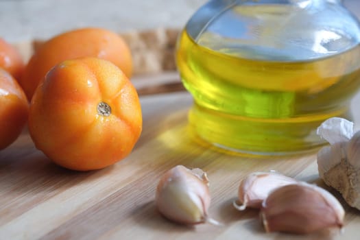 close up of garlic , tomato and olive oil on table .