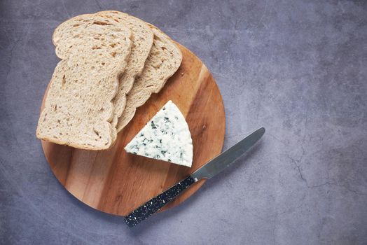 top view of blue cheese ,and slice of brown bread on table .