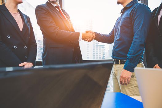 Business partnership meeting handshaking concept. Businessmen doing handshake. Successful business people contract handshaking after finished good dealing with skyscraper window building background.