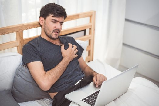 Businessman using laptop computer overnight cause heart attack failure symptom. Healthcare and medical wellness of overworked people lifestyle concept. Technology and workaholic illness theme.